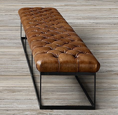 Long rectangular accent bench featuring button-tufted cognac brown leather seating supported by a black metal sled frame base on light wood floors.
