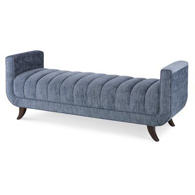 A high-angle view of a mid-century modern slate blue channel-tufted accent bench featuring squared arms and curved dark wood legs over a white background.