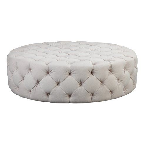 A large, round light beige tufted ottoman coffee table featuring deep diamond button-tufting across the top and sides, isolated against a white background.